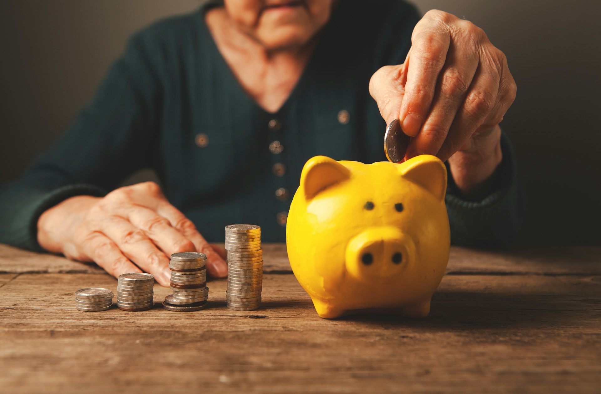 Persona mayor depositando ahorros en una alcancía, opciones de ahorro para el retiro entre Afore y portafolio propio de fondos de inversión