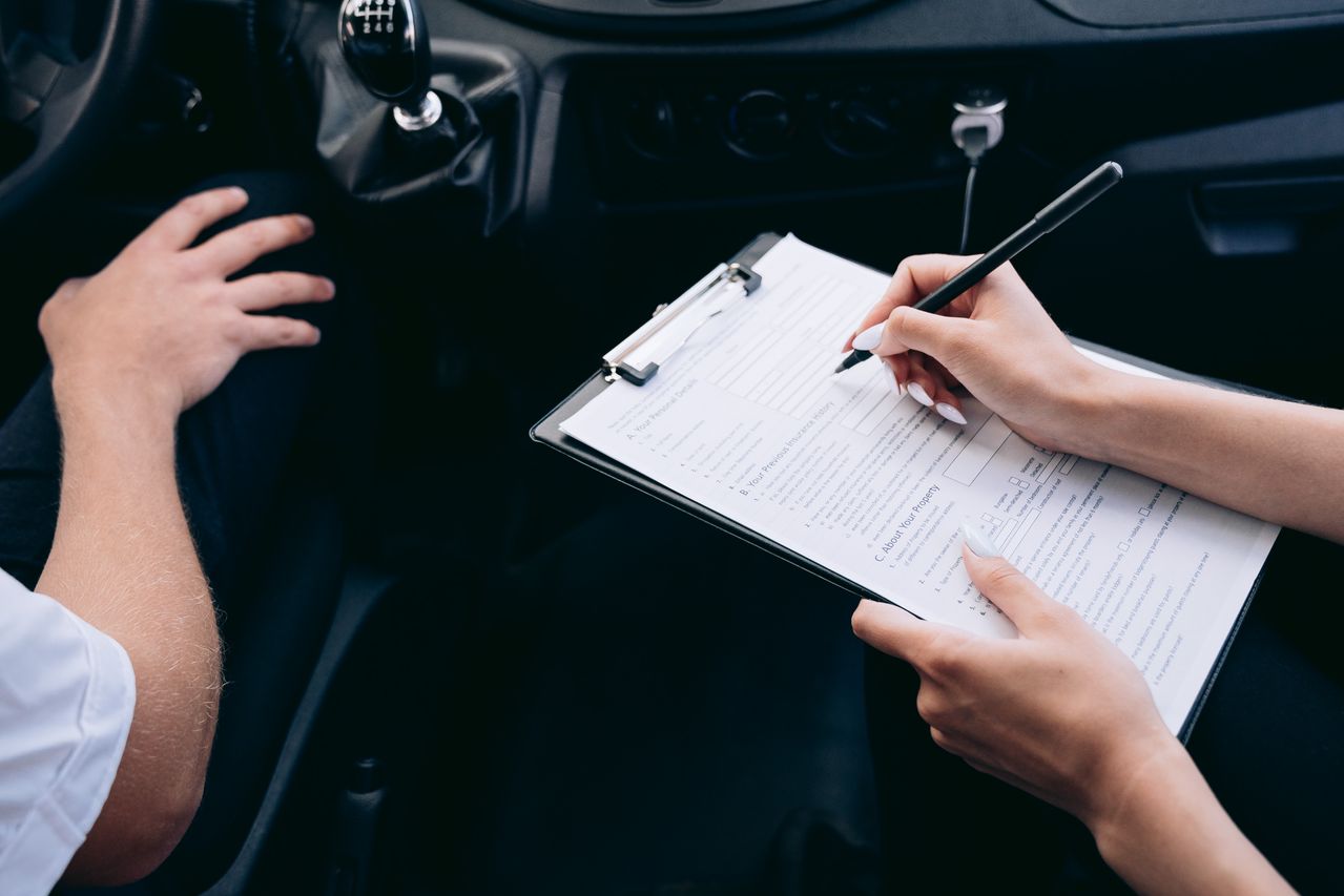 Persona dentro de un coche recibiendo opciones de seguro de coche, revisando coberturas y precios