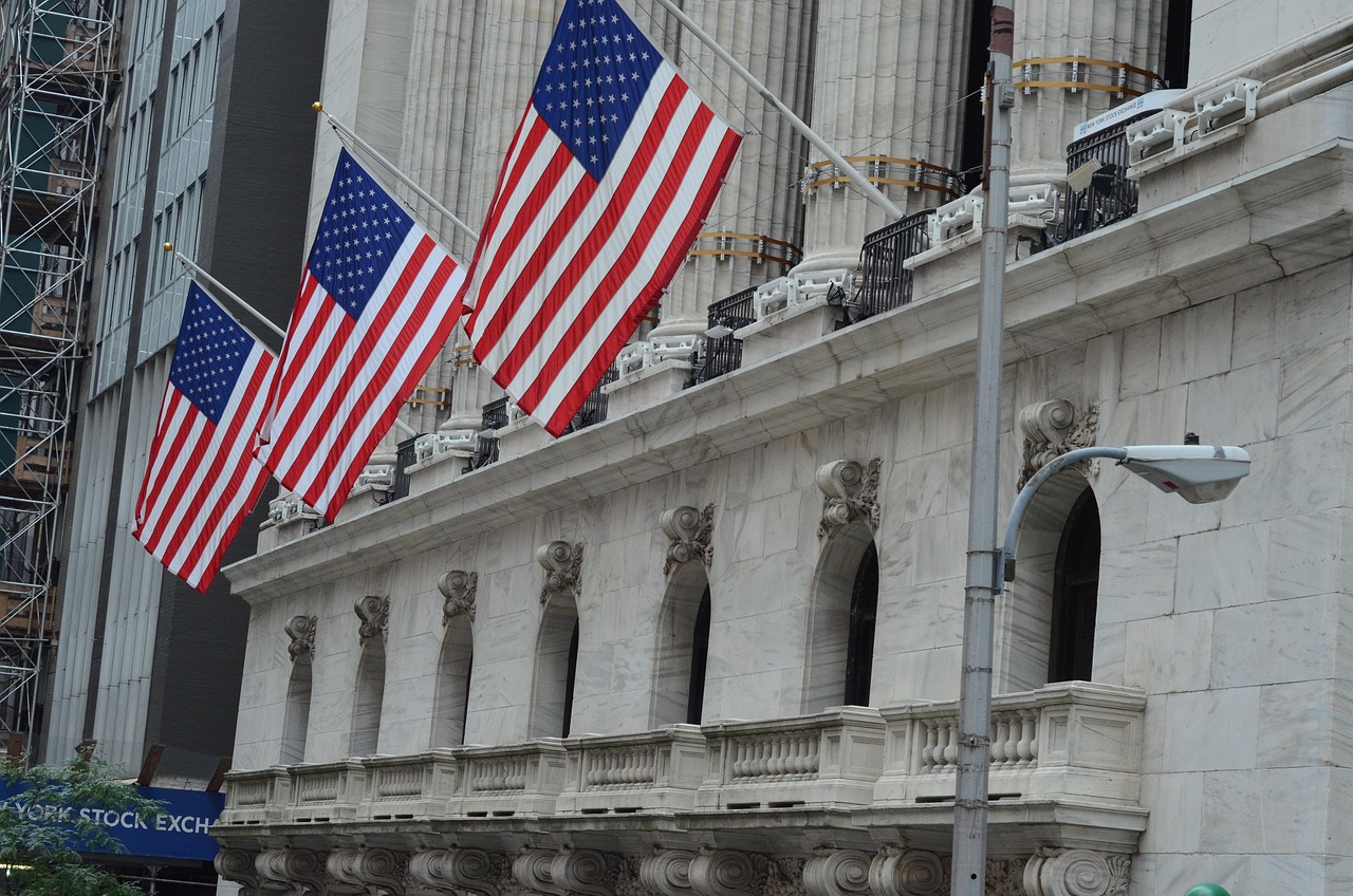 Edificio de Wall Street con banderas norteamericanas, porque se puede invertir en acciones norteamericanas desde México
