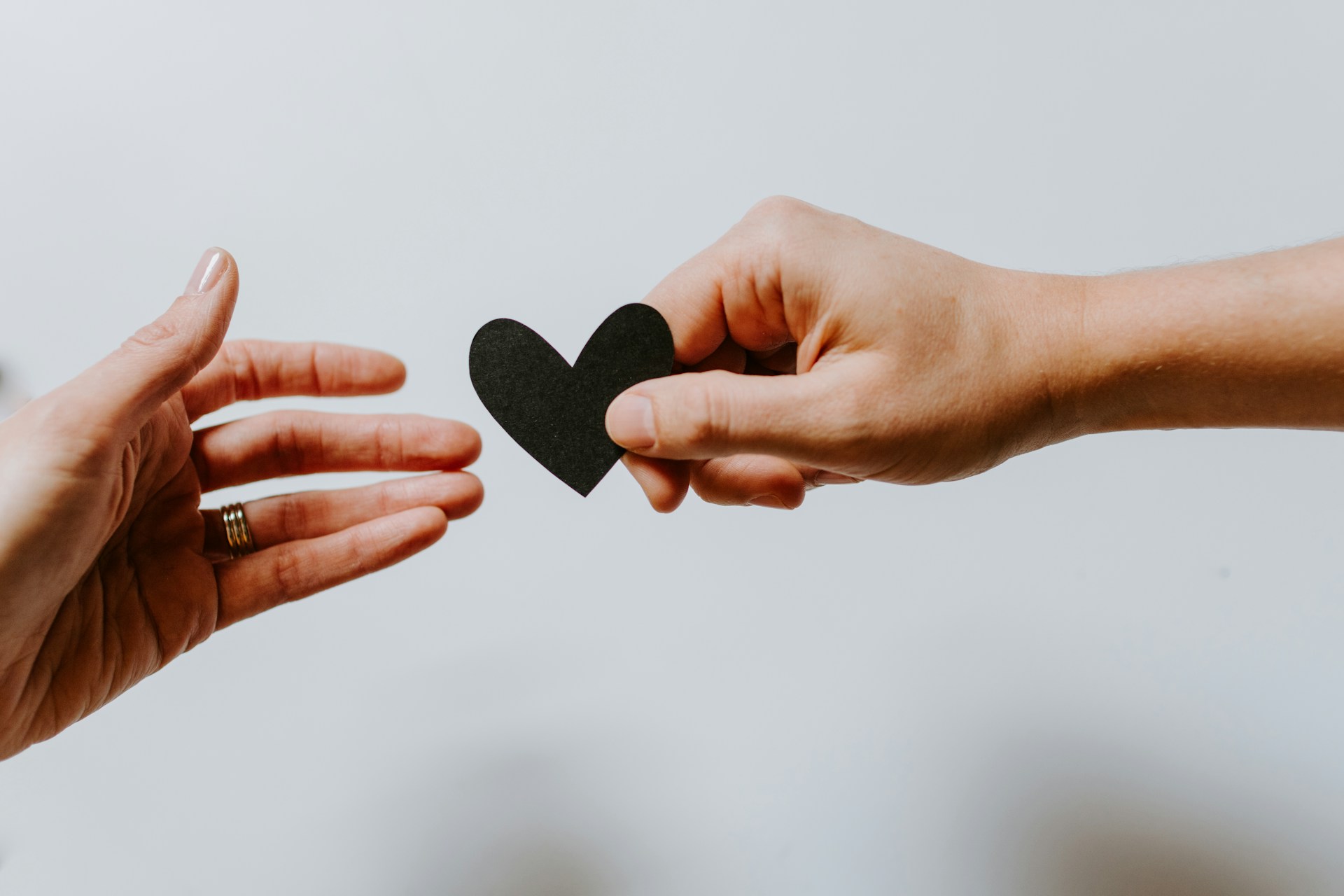 Persona entregando a otra su corazón, representando el paso 7 de Dave Ramsey de crear patrimonio y donar