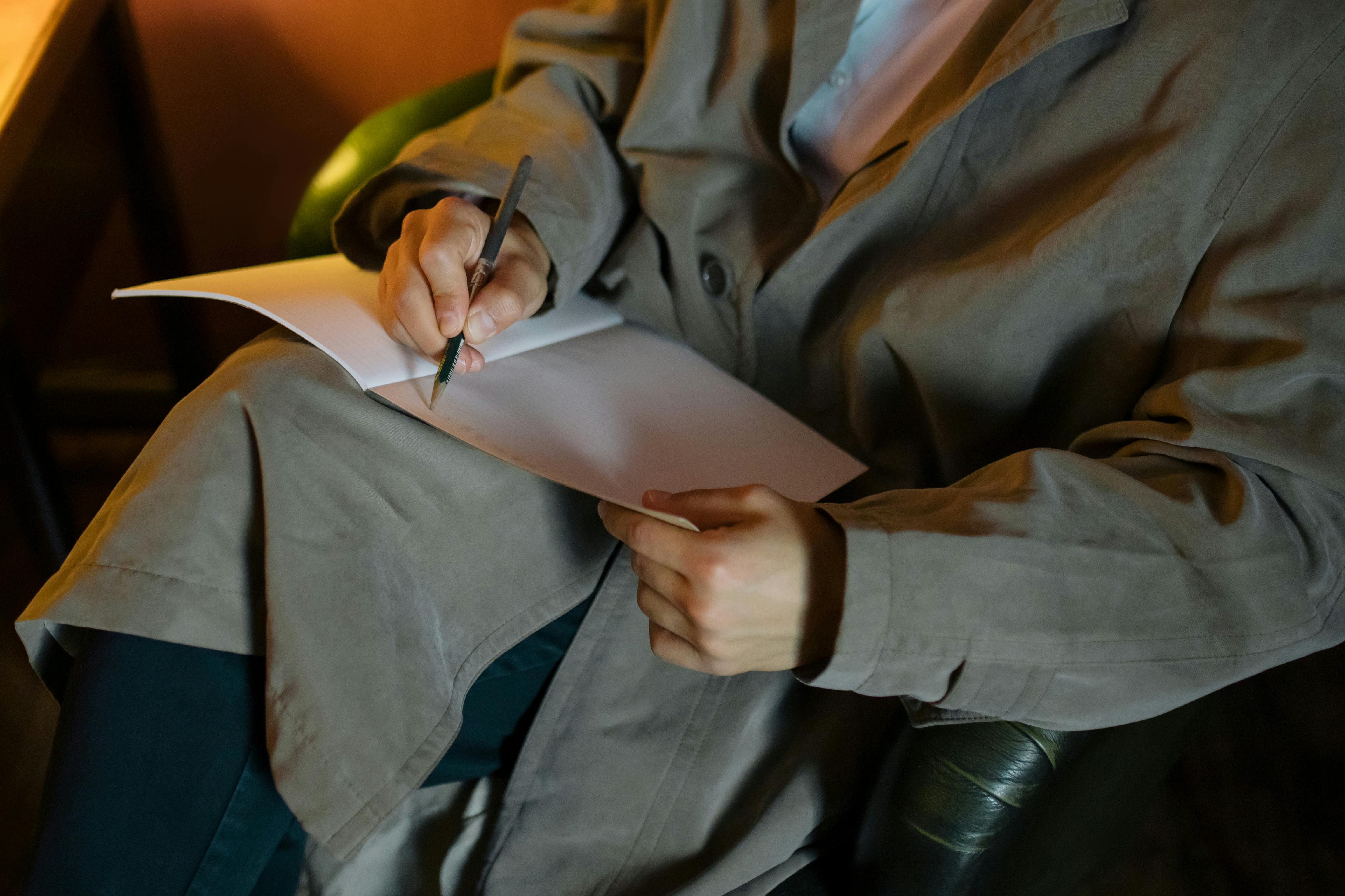 Persona escribiendo en un cuaderno reflexionando sobre su situación financiera