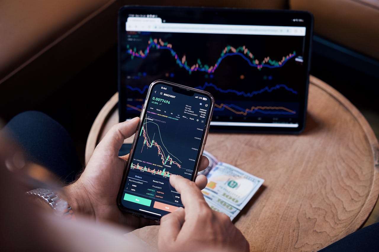Personas analizando pantalla con gráficas de la bolsa de valores, conceptos clave para invertir en acciones y fondos indexados