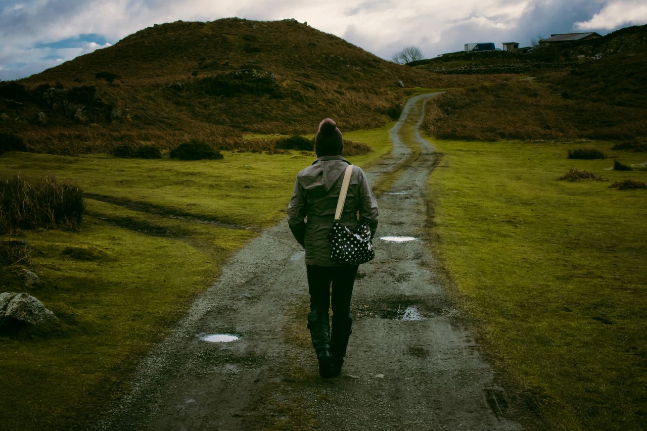 Persona caminando con paso firme sobre un camino irregular representando cómo las finanzas personales sanas permiten navegar un entorno económico adverso