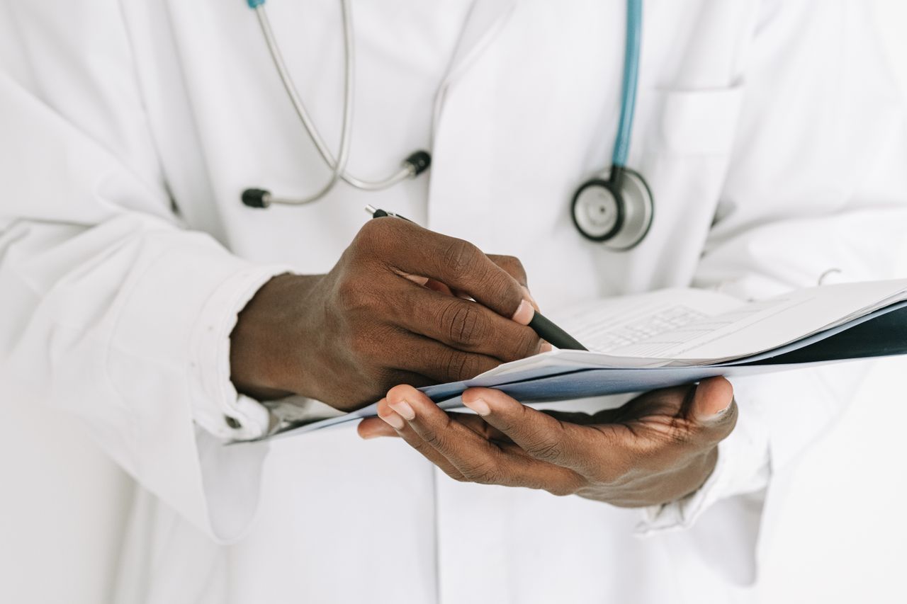 Médico revisando resultados de diagnóstico antes de recomendar tratamiento, metáfora de asesoría financiera personalizada