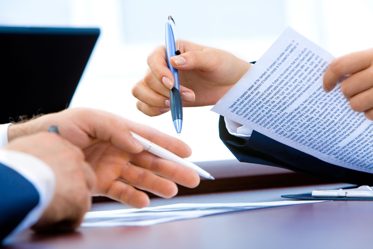 Persona firmando un contrato con una reparadora de crédito Resuelve tu Deuda