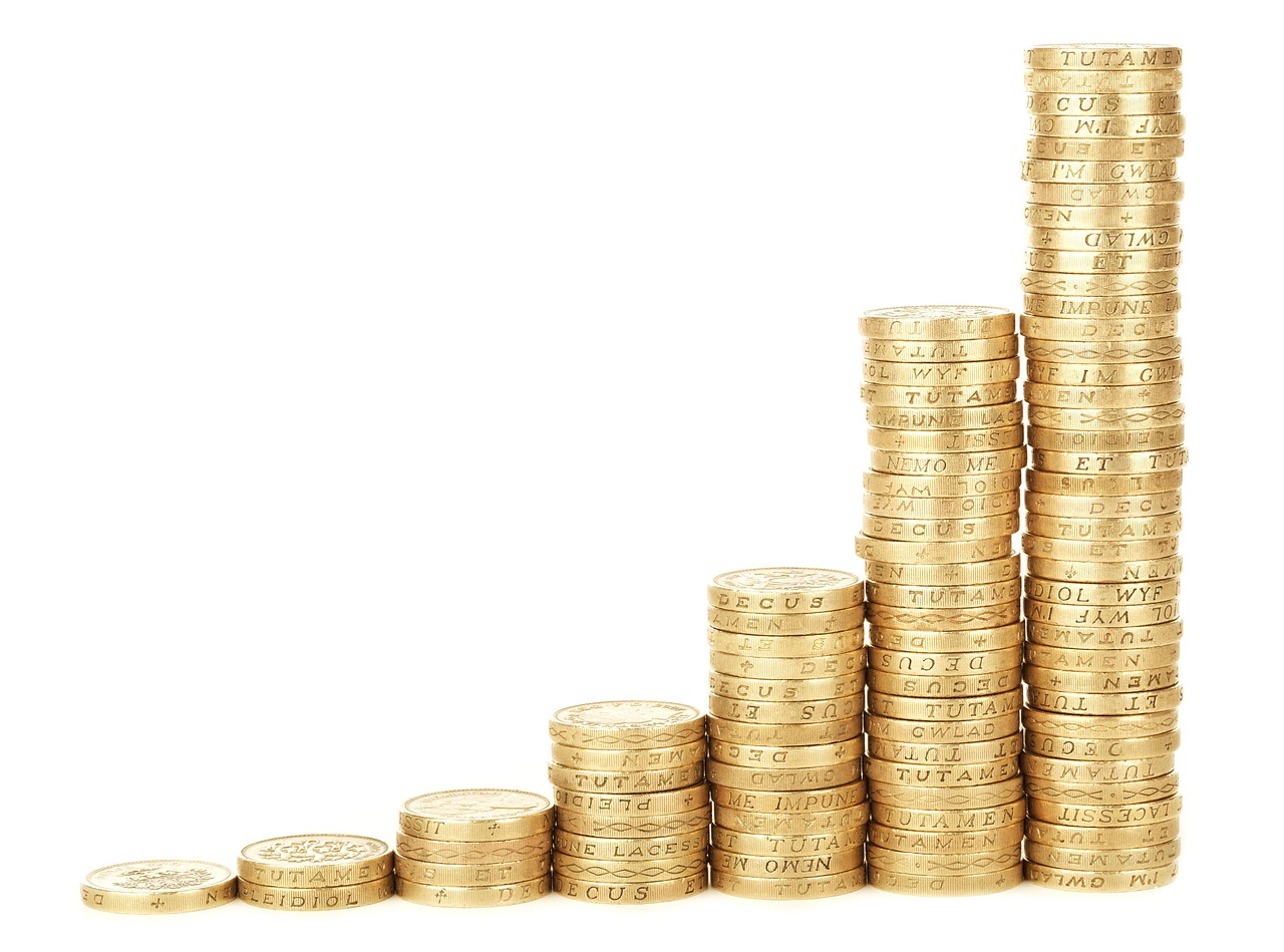 Pilas de monedas creciendo exponencialmente que ilustra la magia del interés compuesto