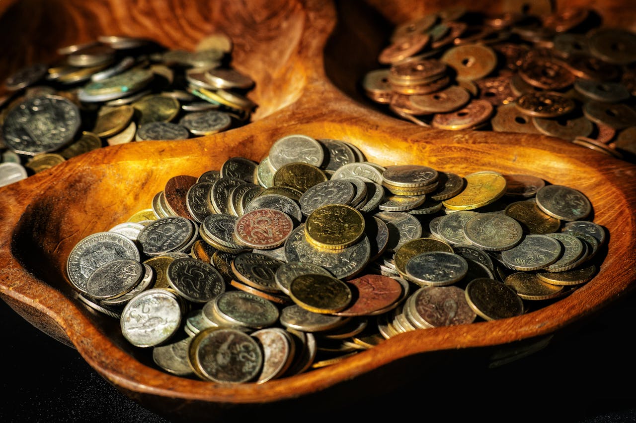 Múltiples monedas convergiendo hacia un solo recipiente representando el concepto de fondo de inversión como pool colectivo de recursos
