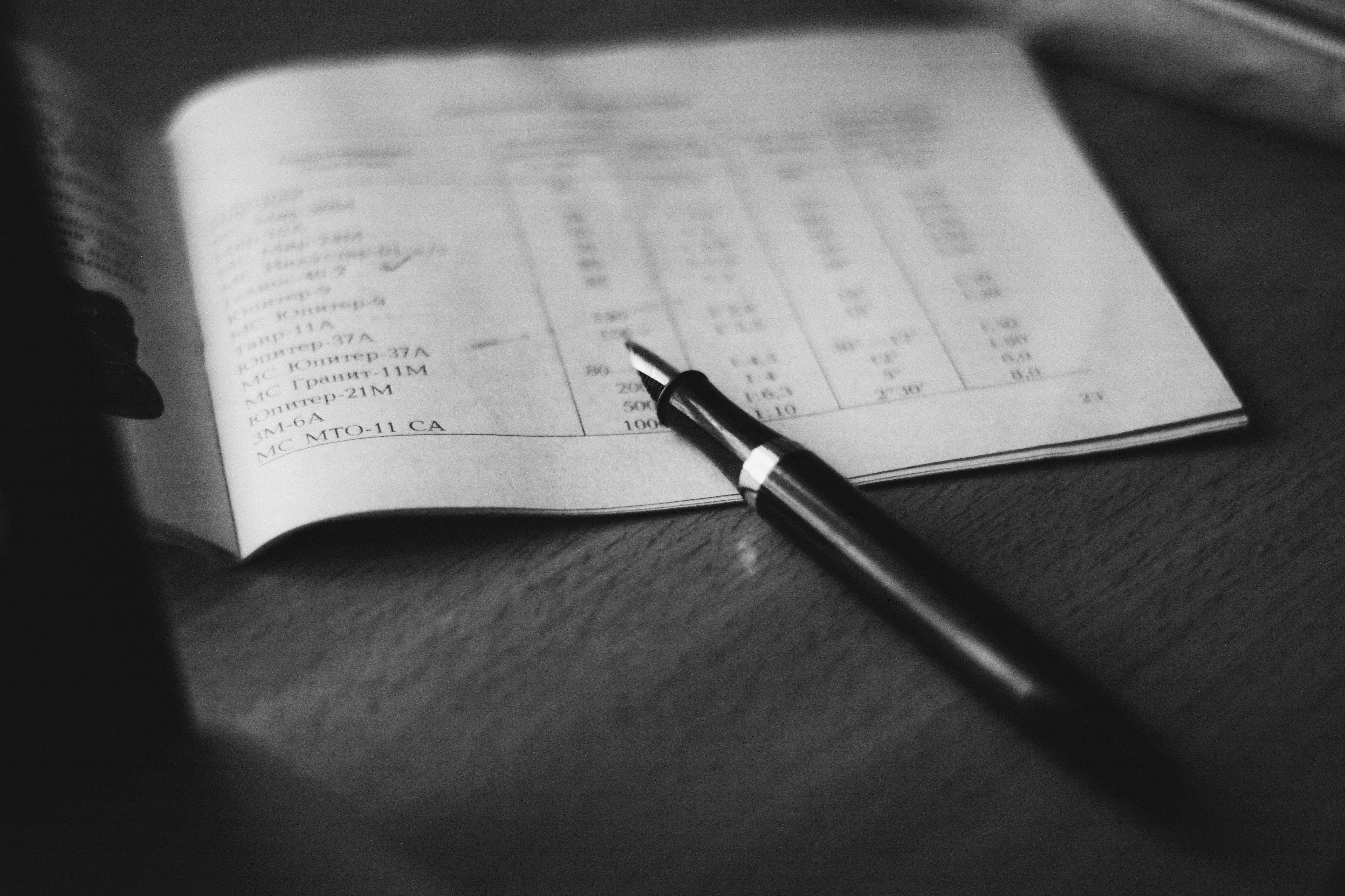Cuaderno con registros de ingresos y gastos personales junto a una hoja de balance, representando los estados financieros personales