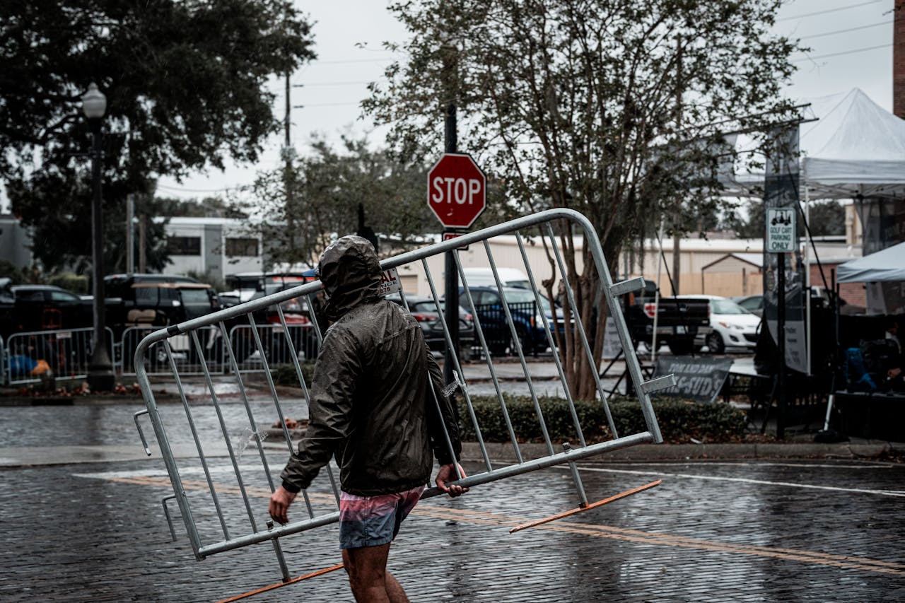 Hombre poniendo vallas de protección durante una tormenta, como metáfora de cómo protegerse de la volatilidad en los mercados
