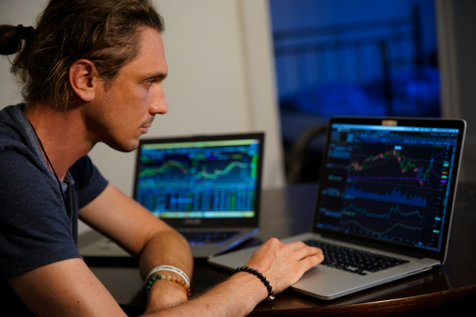 Pantallas con gráficas de trading en bolsa, ilustrando las dos formas de invertir en acciones: trading de corto plazo e inversión de largo plazo