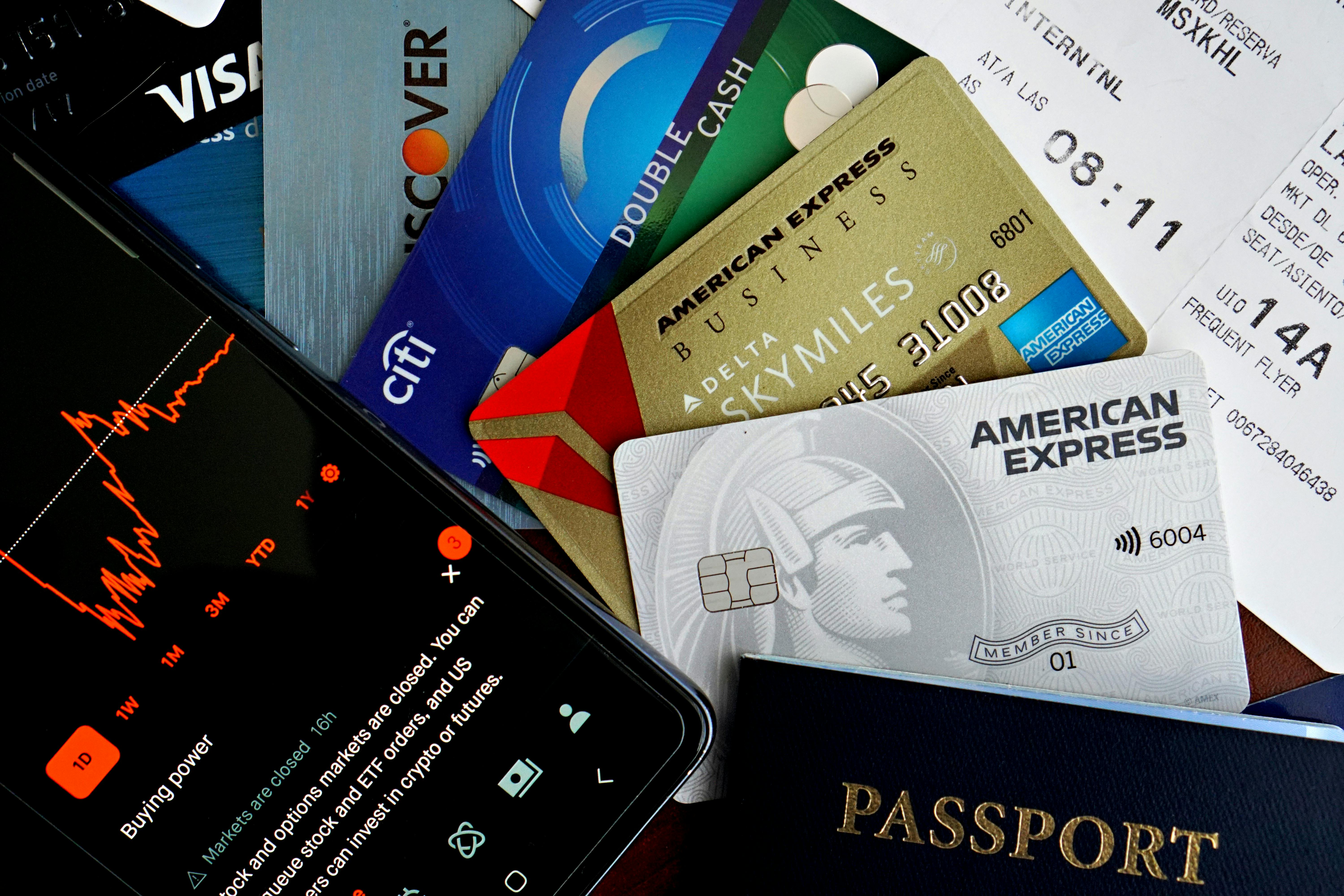 Persona con teléfono y varias tarjetas de crédito - mejoran su calificación crediticia