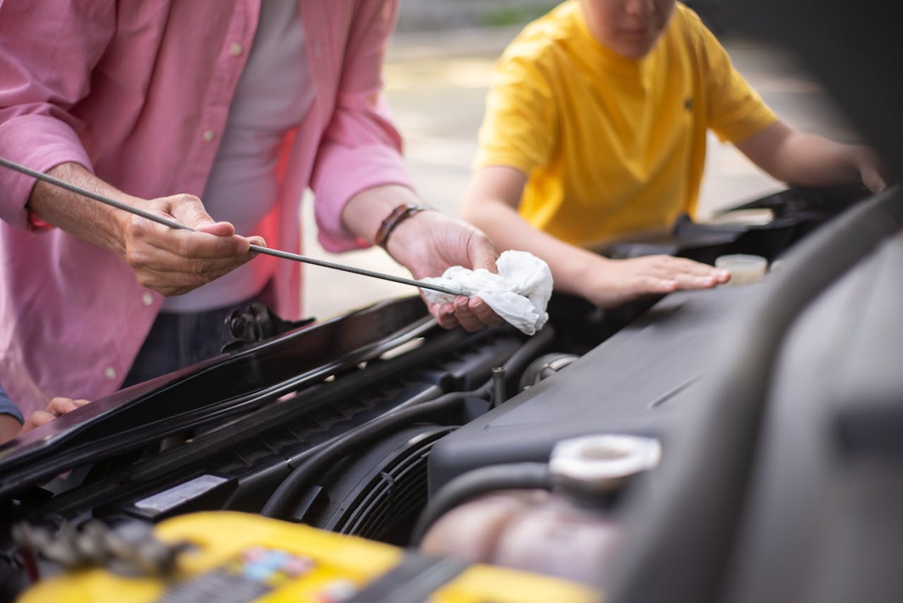 Persona realizando mantenimiento preventivo a su automóvil, cuidado de bienes como forma de ahorro