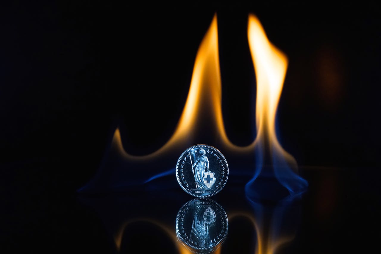 moneda con fuego detrás porque se está quemando por la Inflación y el riesgo que son dos conceptos fundamentales en inversiones