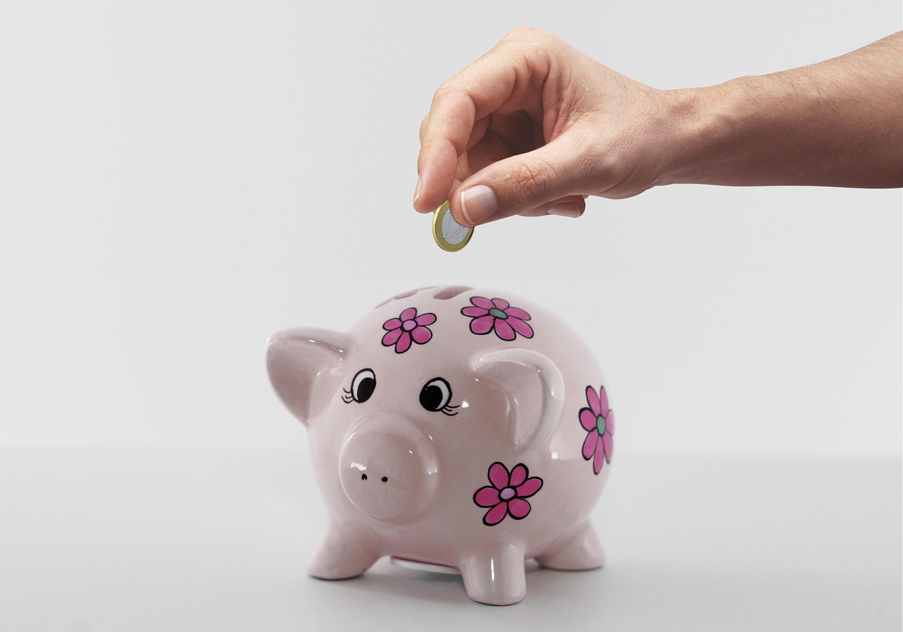 Manos depositando una moneda representando el método de ahorro gradual y constante para invertir en Cetesdirecto