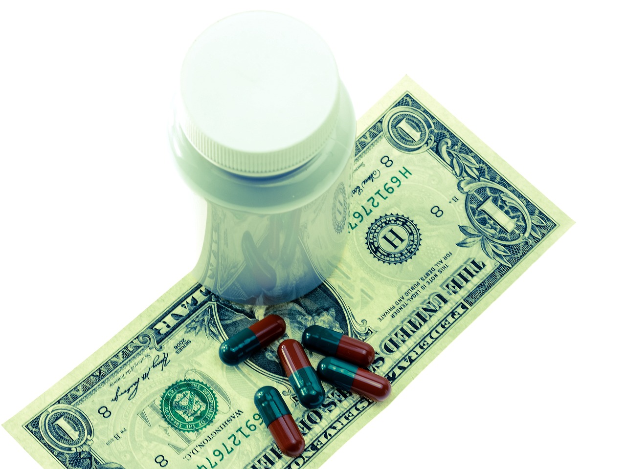 Pastillas sobre billete de dólar, señalando el fin de los seguros de gastos médicos ilimitados en México