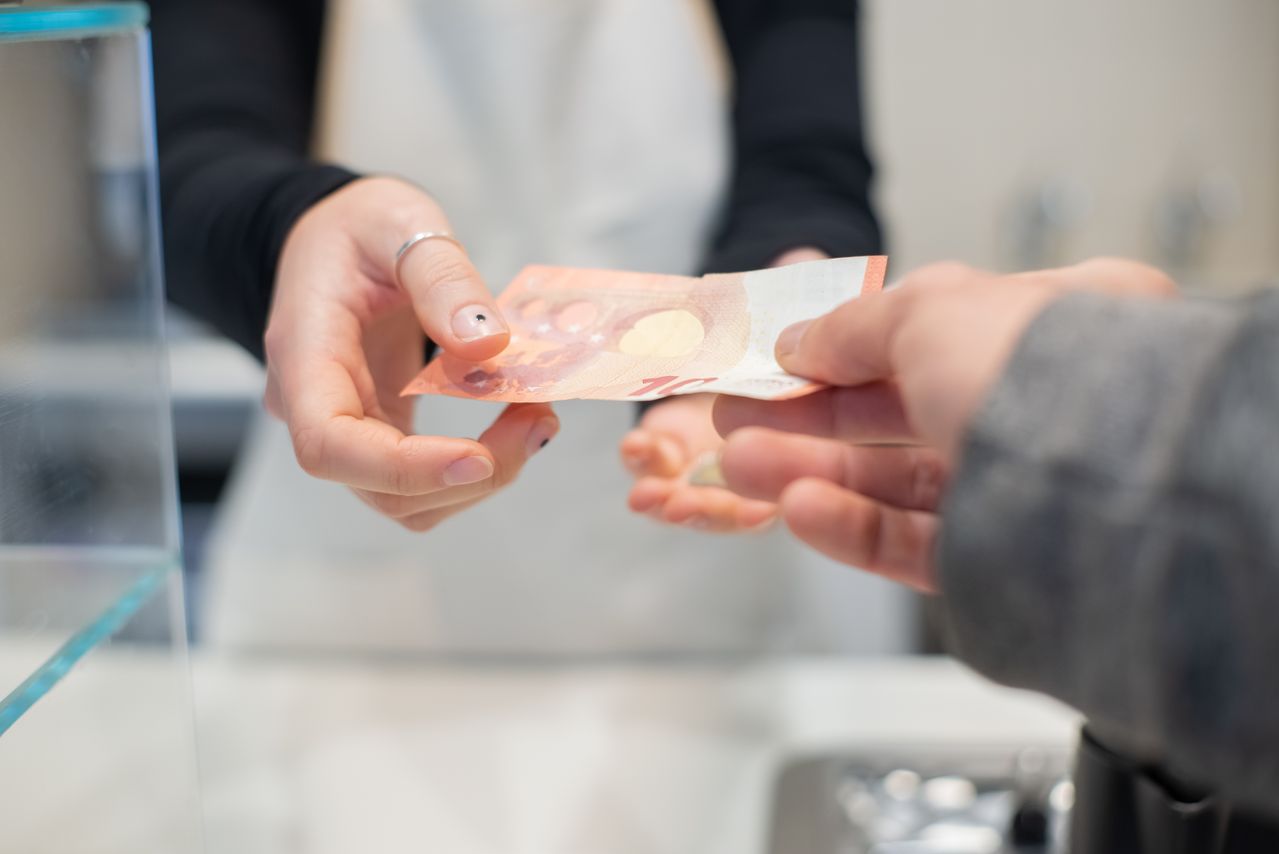 Persona pagando en efectivo como alternativa inteligente al crédito